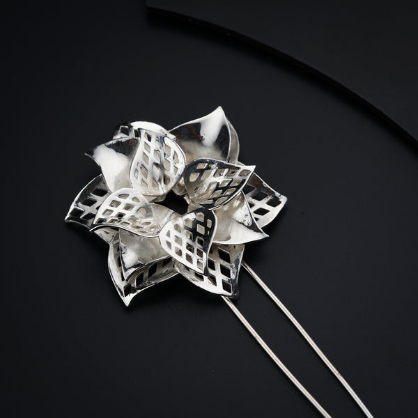 a close up of a metal flower on a black surface