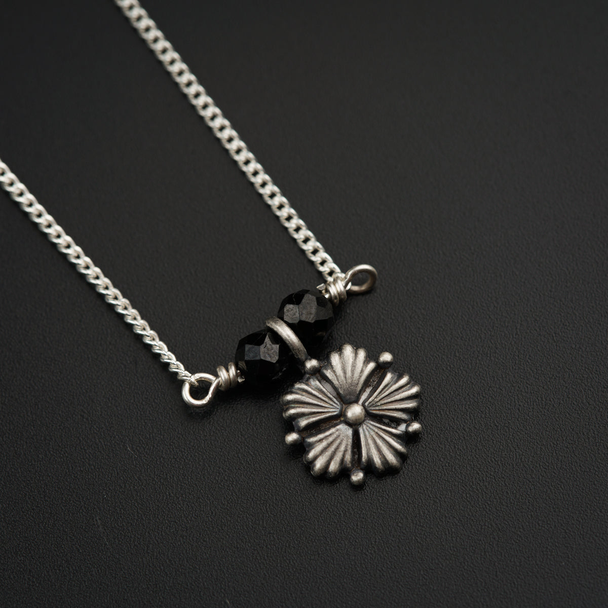 a black and white photo of a flower on a chain