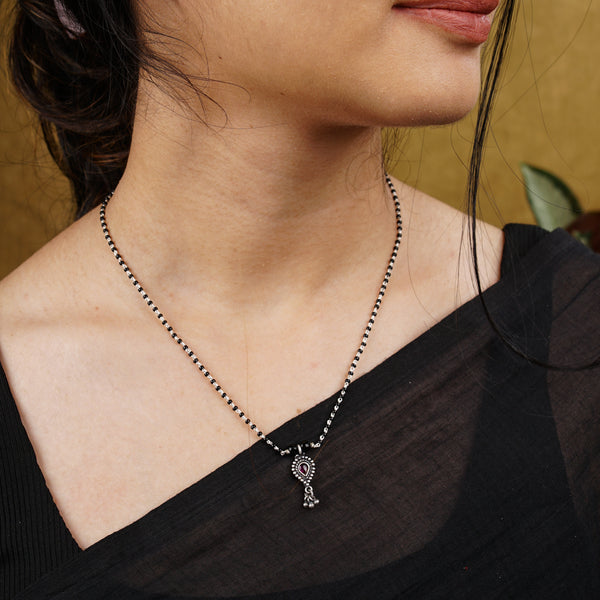 a woman wearing a necklace with a cross on it