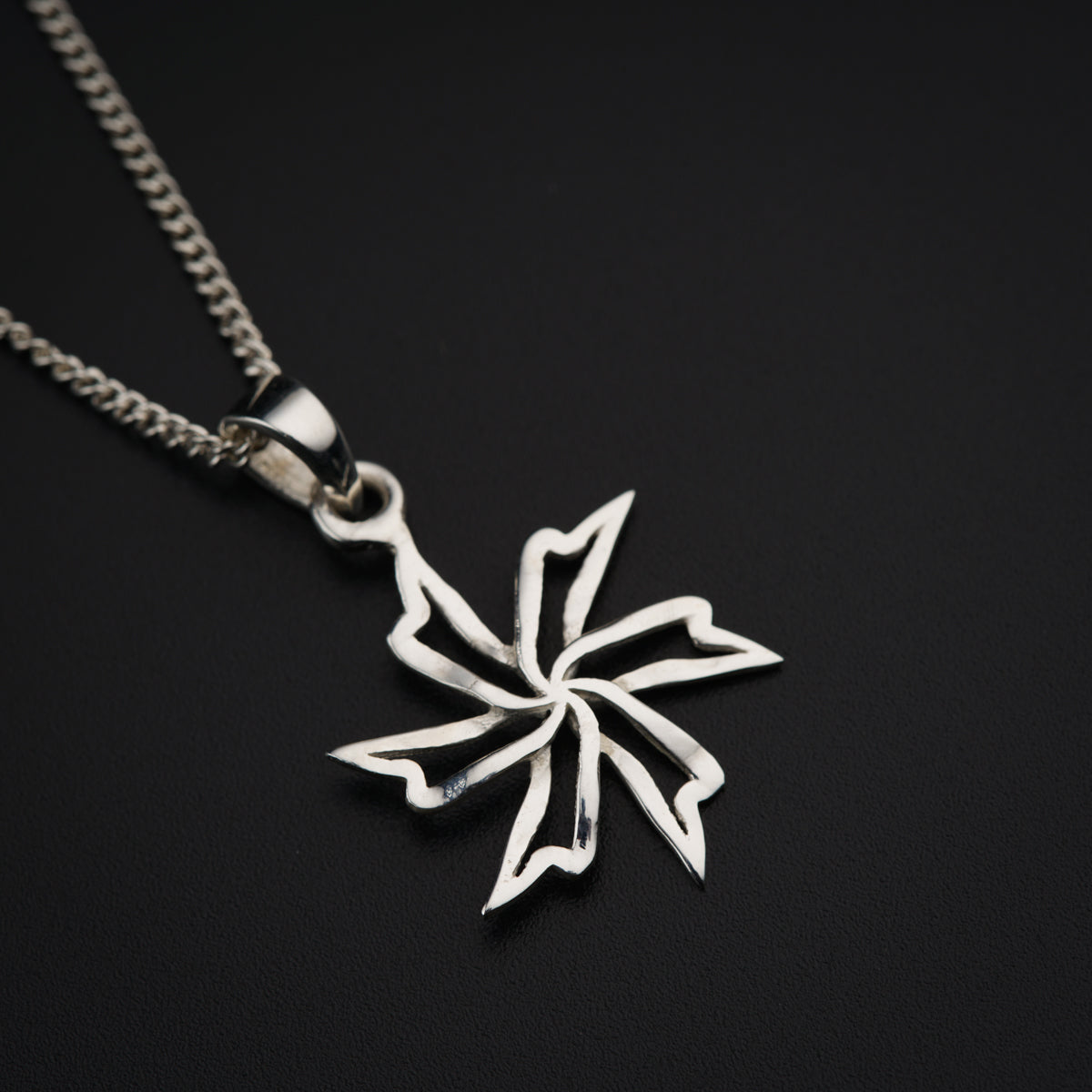 a silver necklace with a flower on a chain
