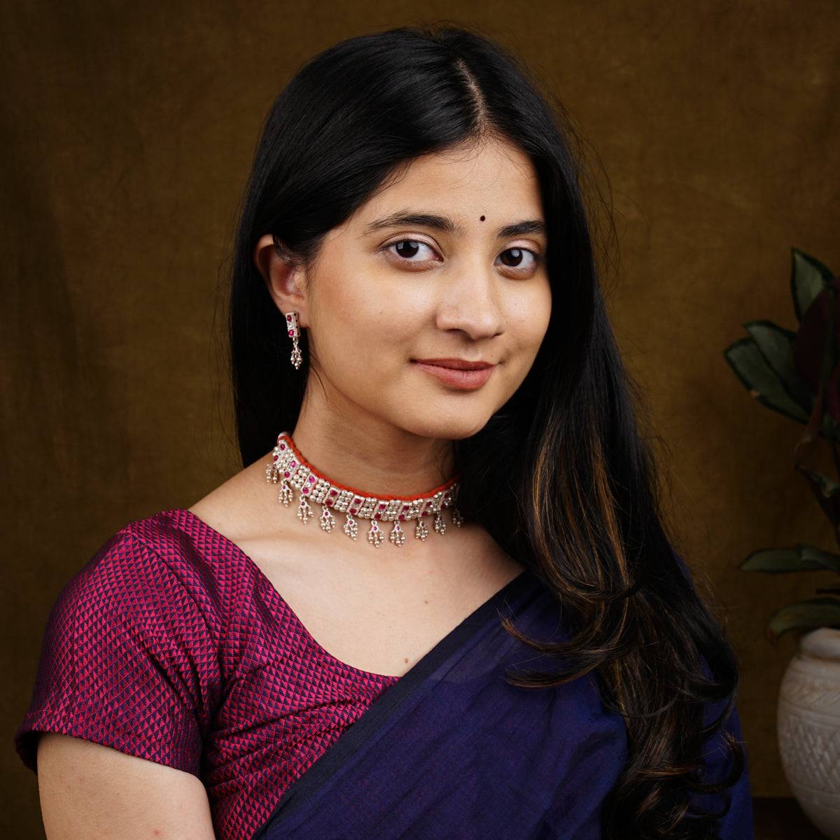 a woman wearing a purple sari and a necklace