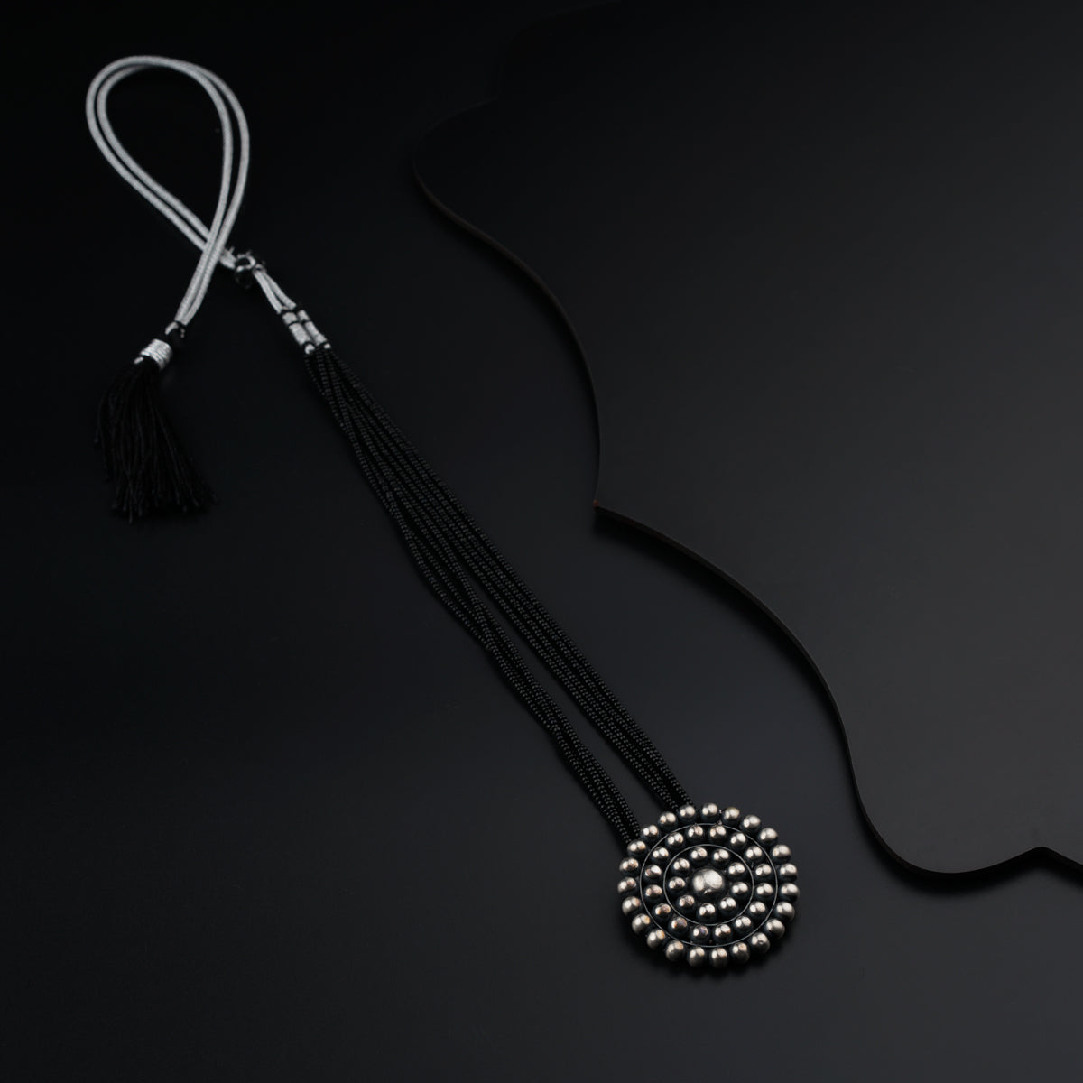 a black and white necklace on a black background