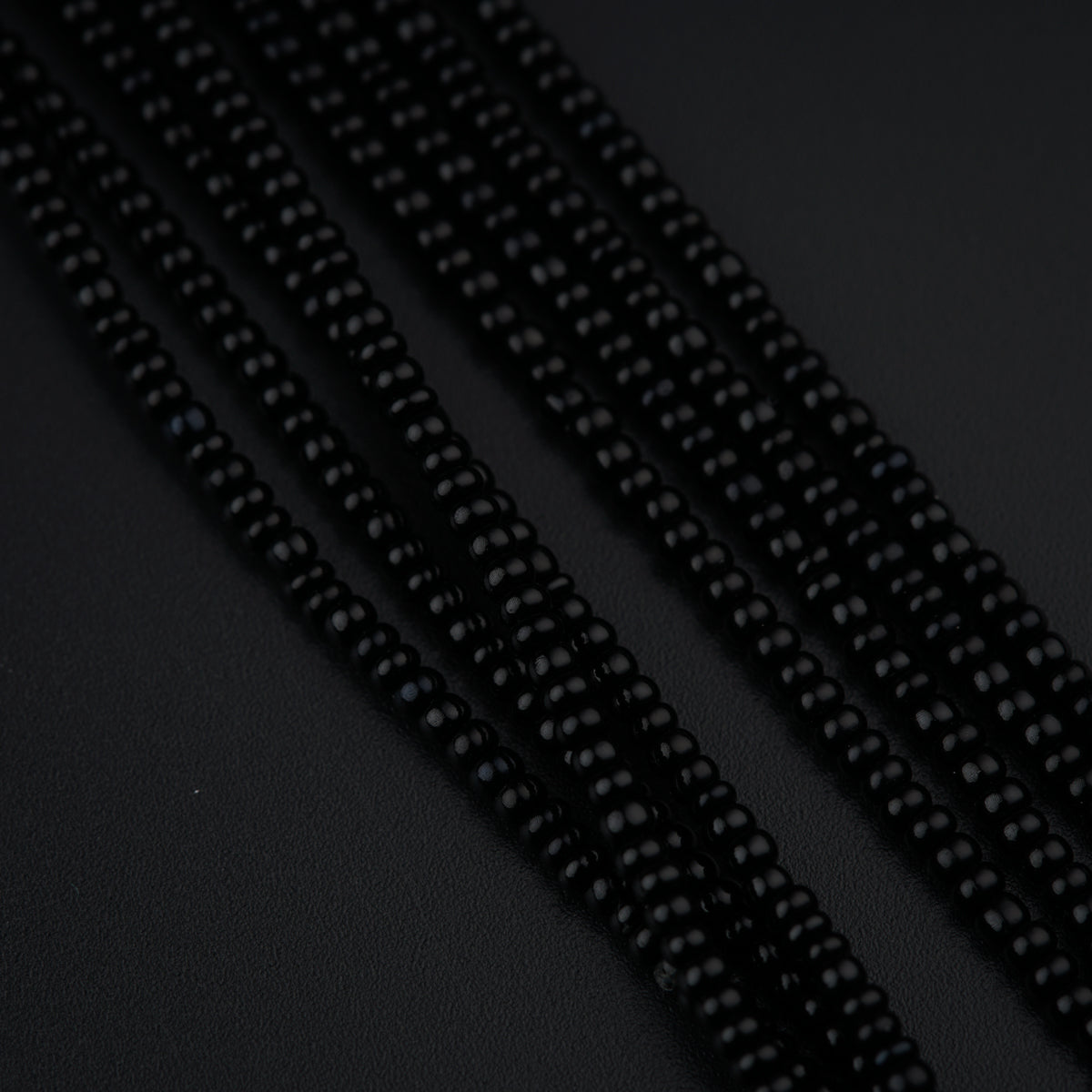 a close up of beads on a black surface
