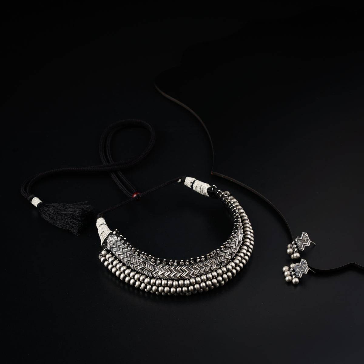 a black and white necklace with a tassel