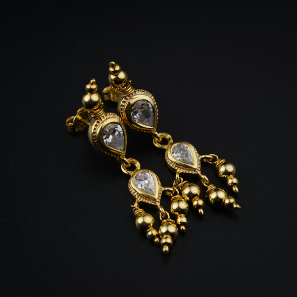 a close up of a pair of earrings on a black surface