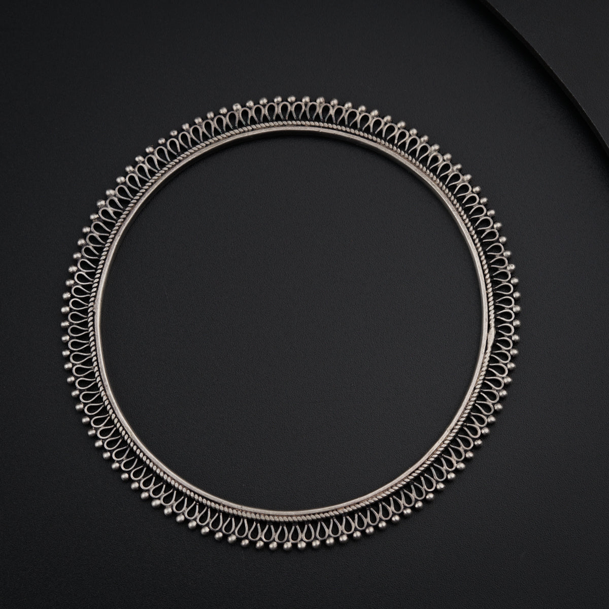 a circular metal object on a black surface