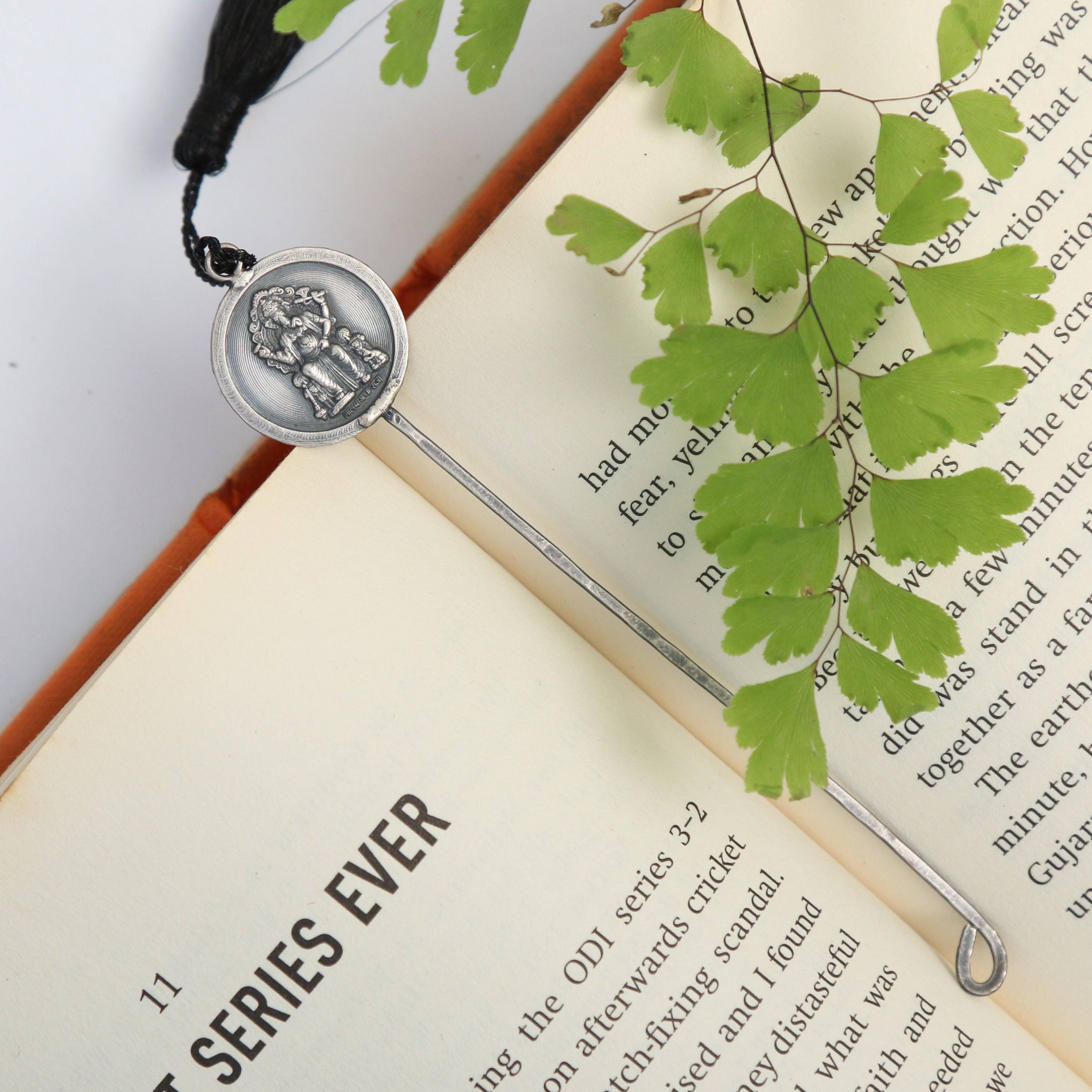 a book with a bookmark and a leaf on top of it