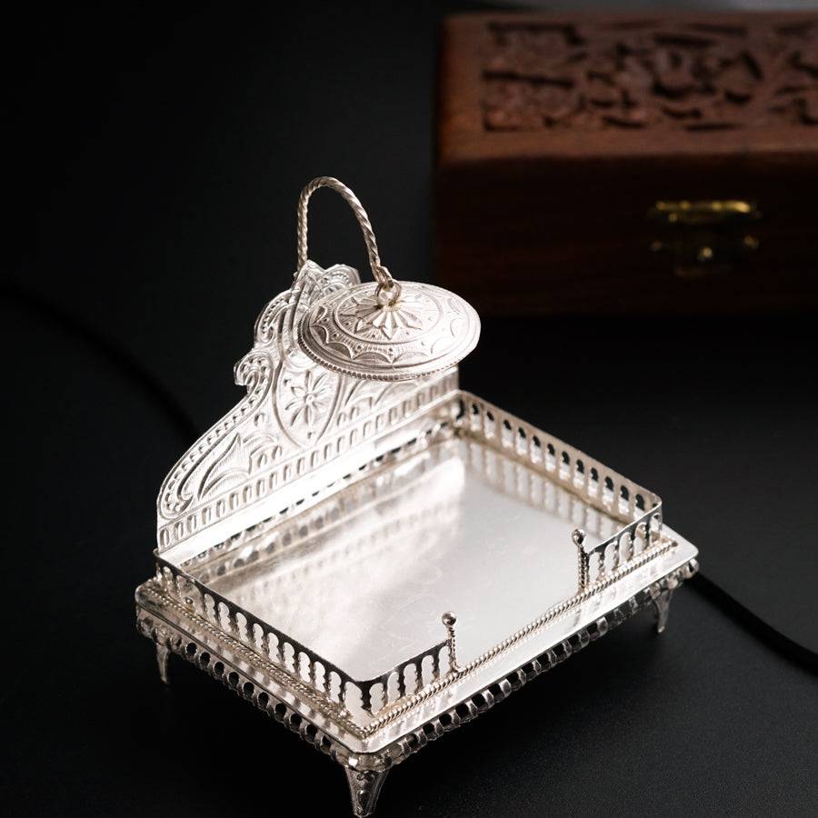 a silver tray with a mirror on top of it