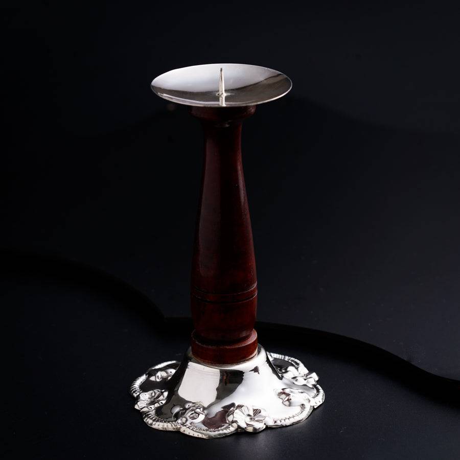 a candle holder on a table with a black background
