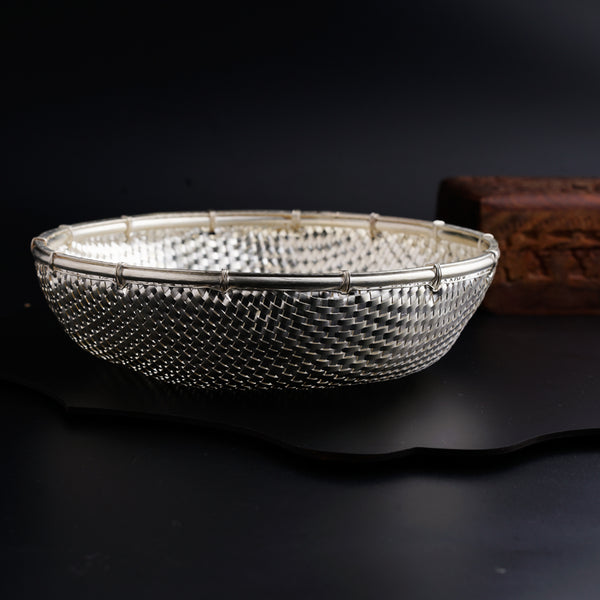 a silver bowl sitting on top of a black table
