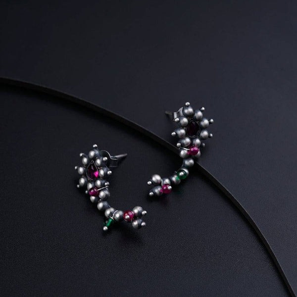 a close up of a pair of earrings on a black surface