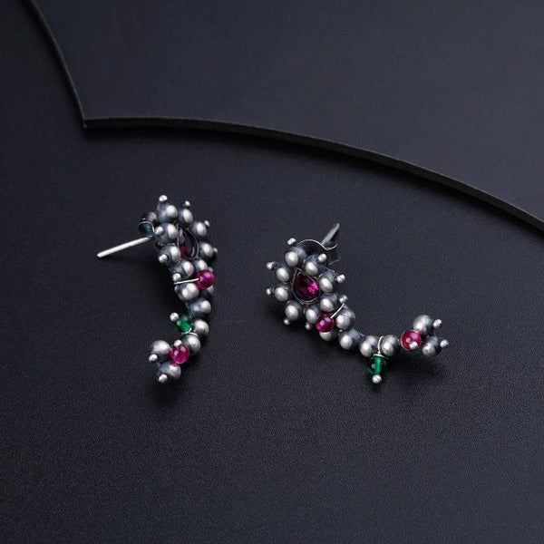 a pair of earrings on a black surface