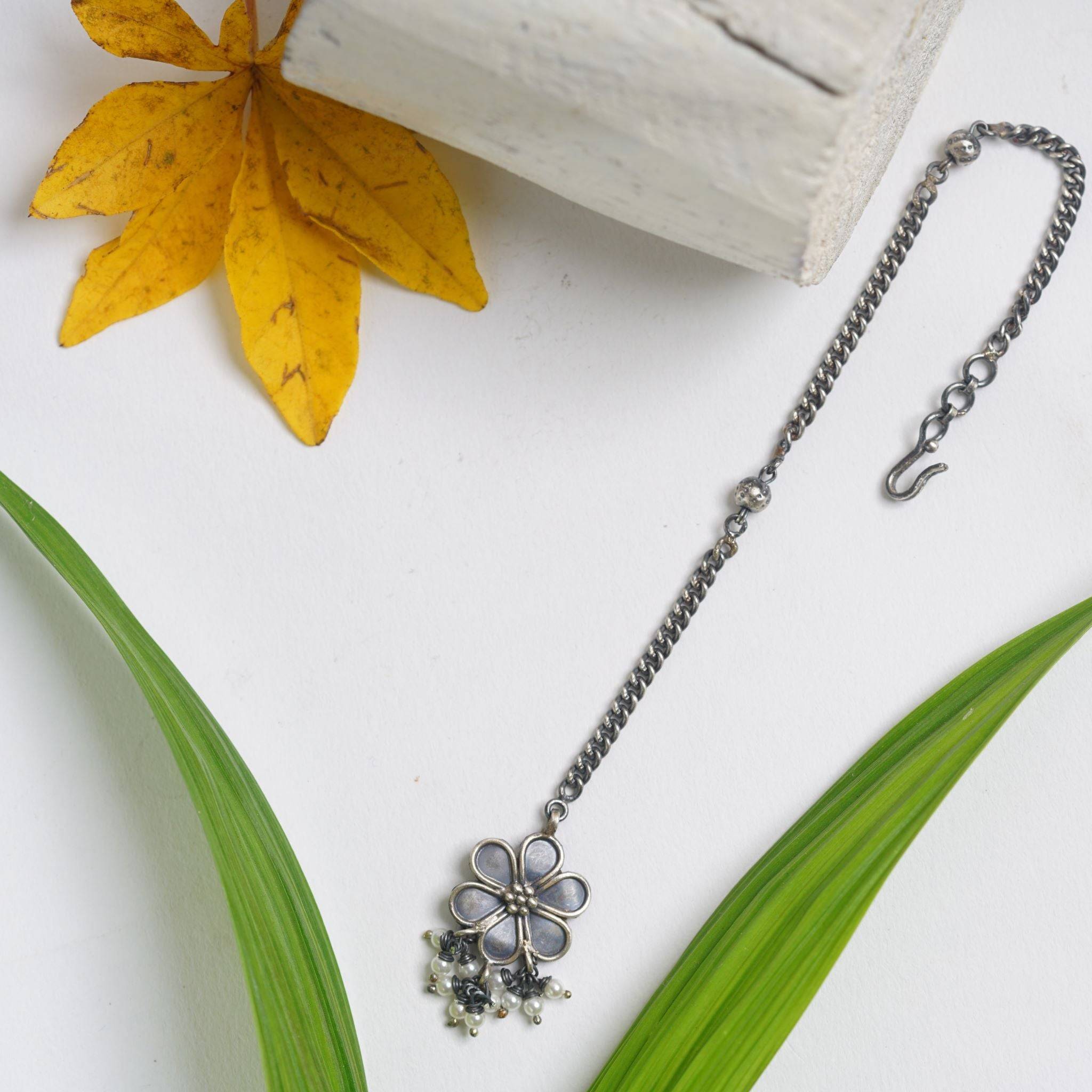 a necklace with a flower on a chain