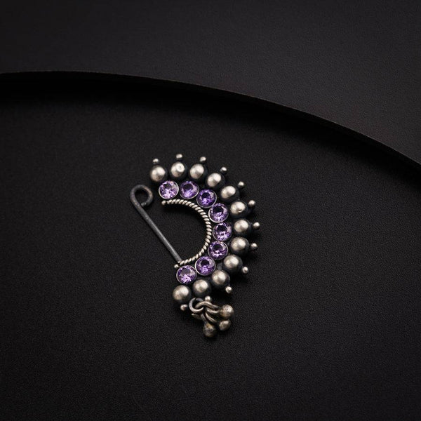 a close up of a brooch on a black surface