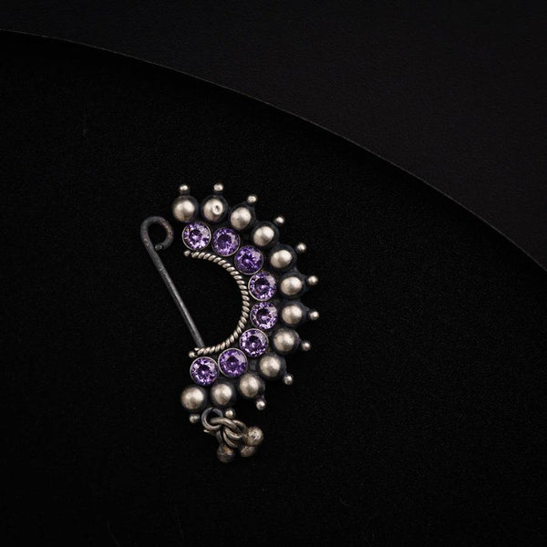 a close up of a brooch on a black surface