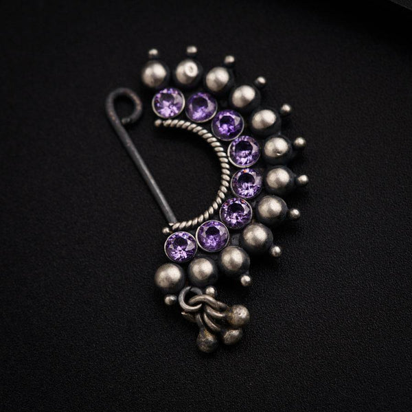 a close up of a brooch on a black surface