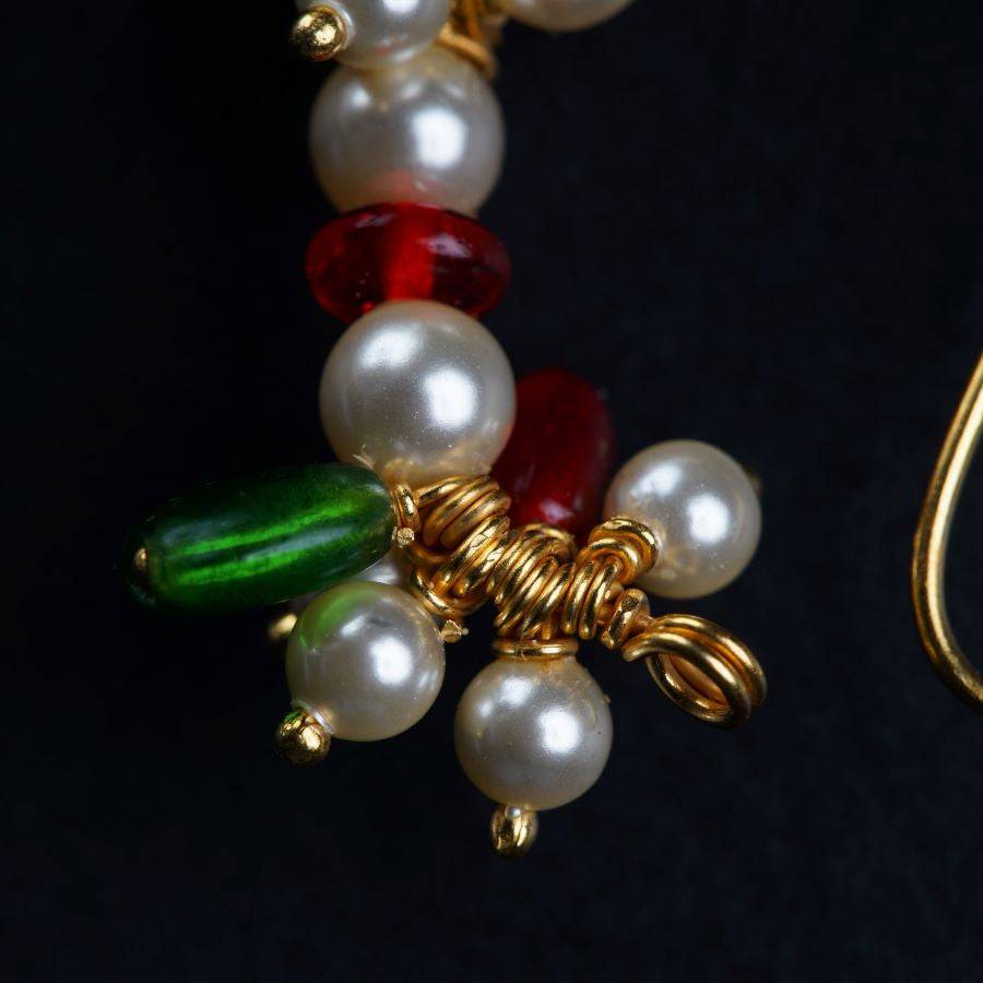 a close up of a pair of earrings with pearls