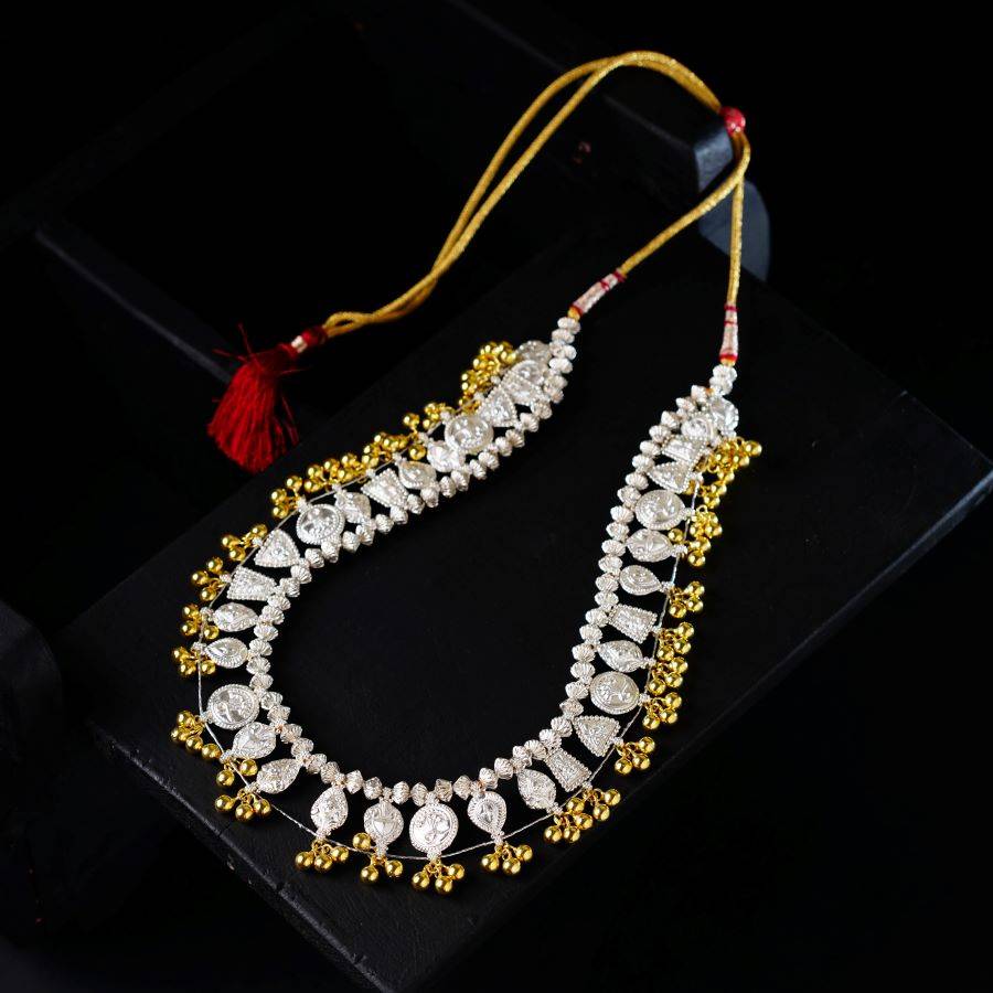 a gold and white necklace with a tassel