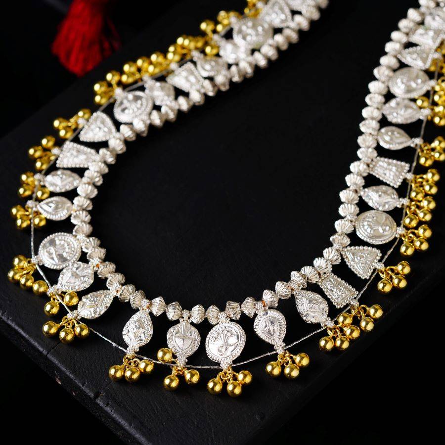 a gold and white necklace on a black surface