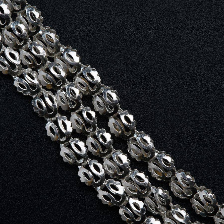 a close up of a chain of beads on a black surface