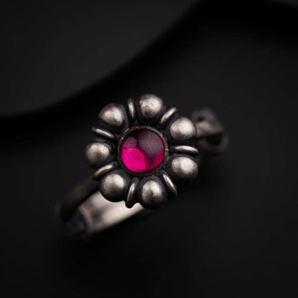a close up of a ring with a red stone