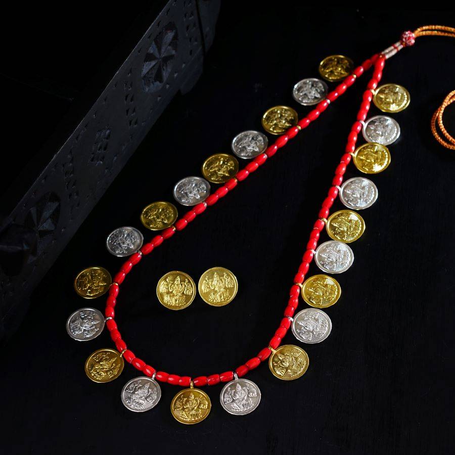 a red beaded necklace with gold and silver coins