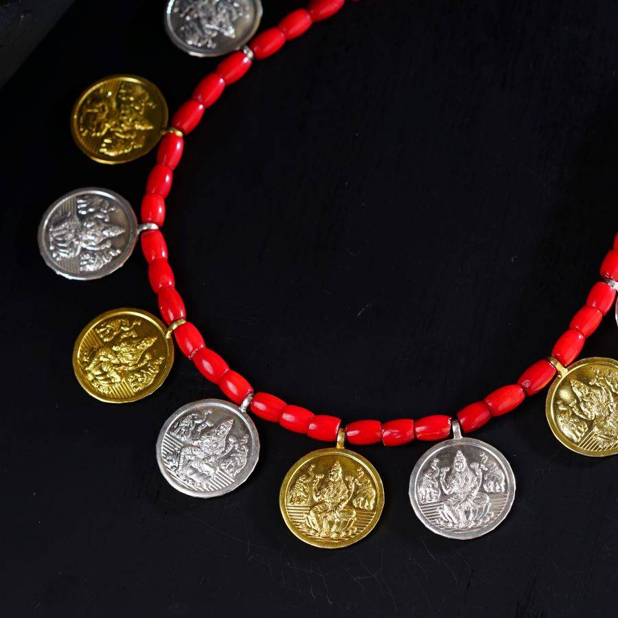 a red beaded necklace with gold and silver coins