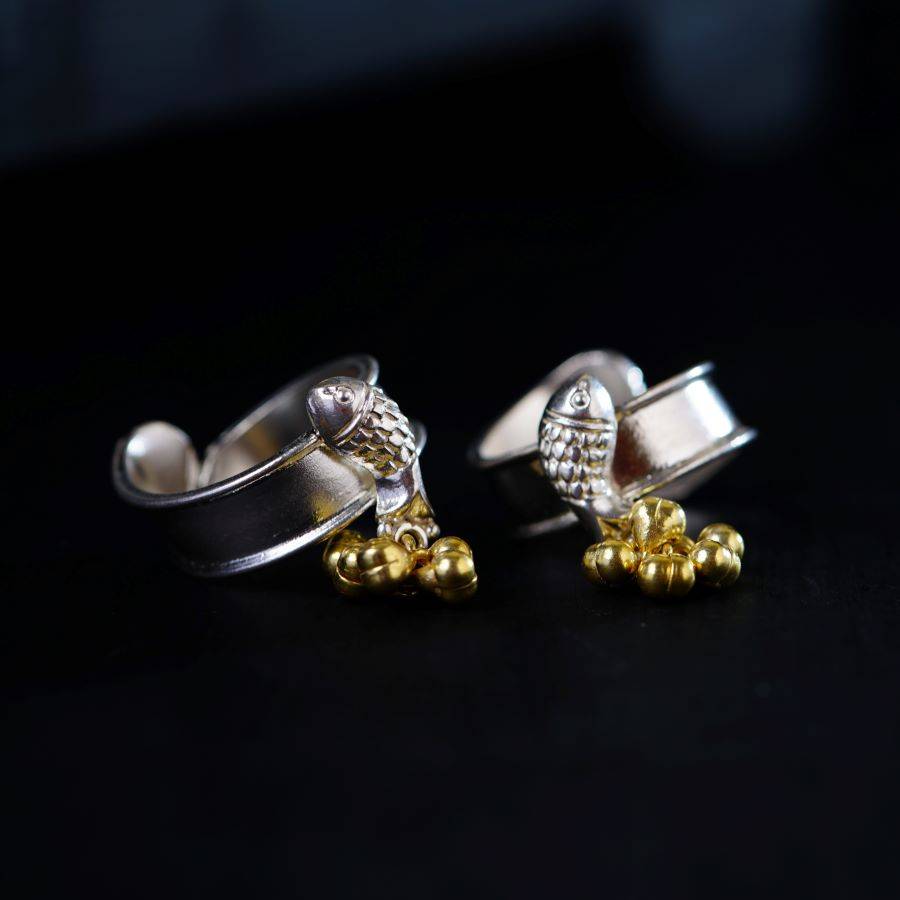 a pair of silver and gold rings on a black surface