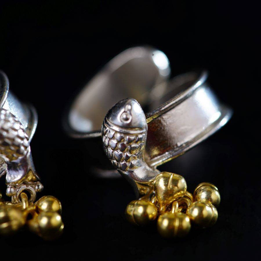 a pair of silver and gold cufflinks on a black background