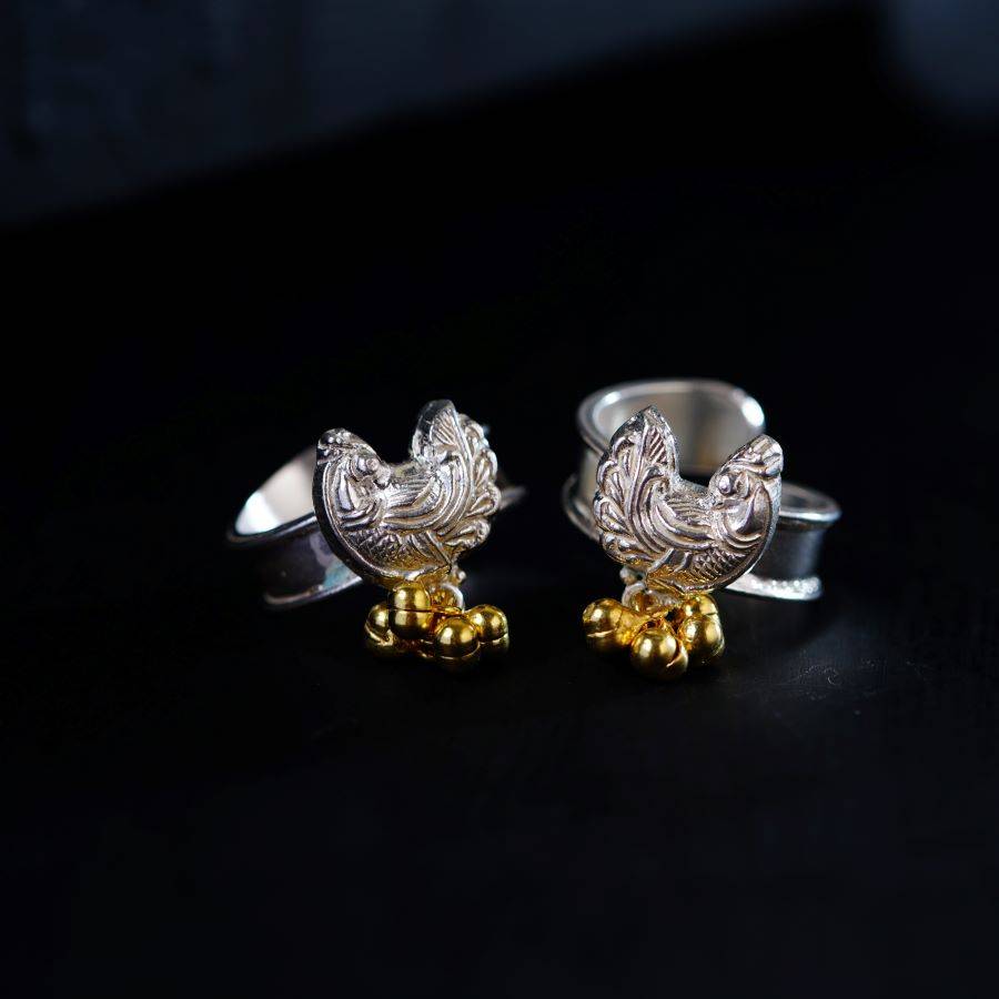 a pair of silver and gold rooster rings