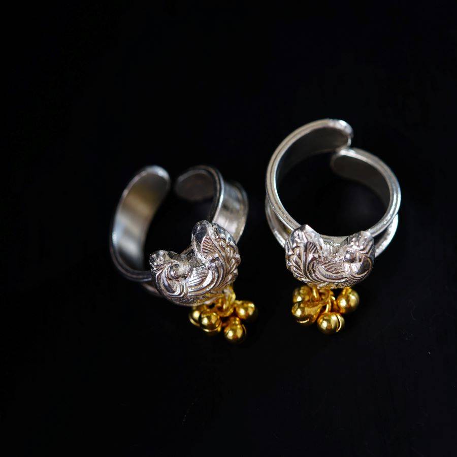 a pair of silver and gold rings on a black background