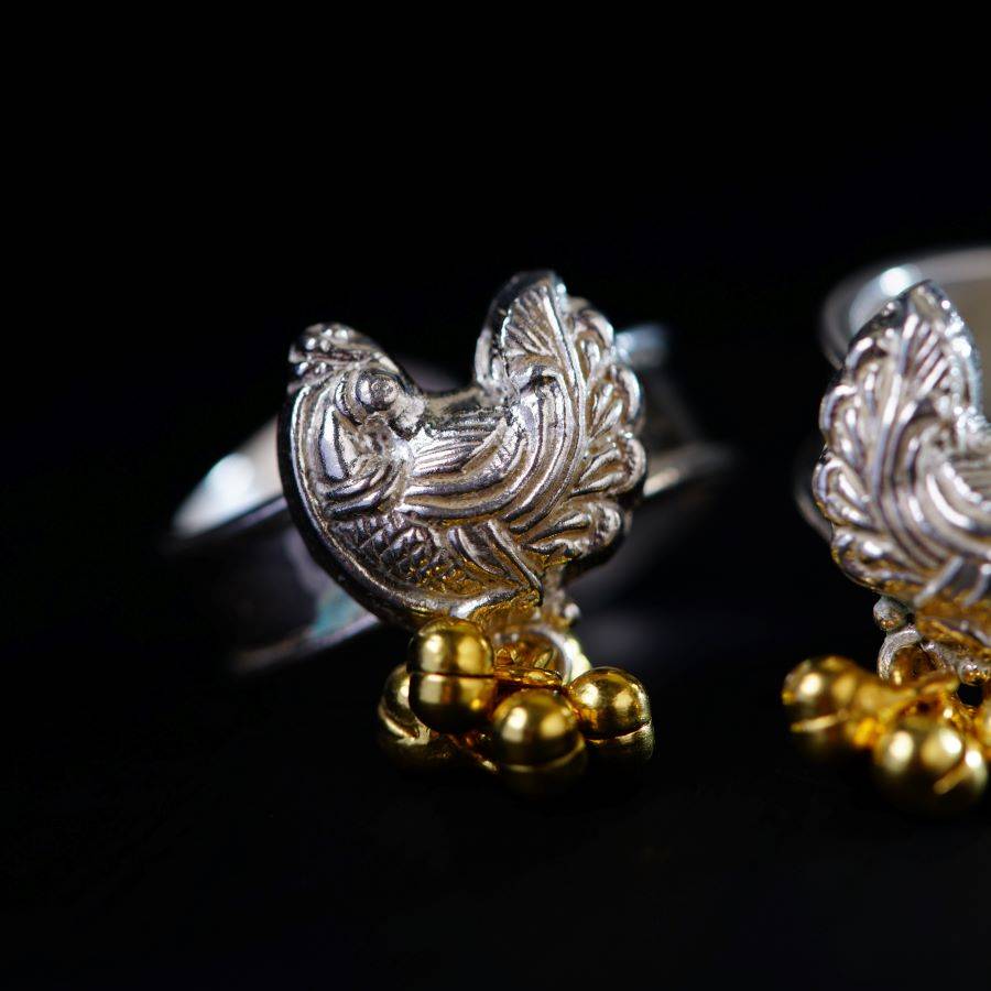 a pair of silver and gold rooster cufflinks