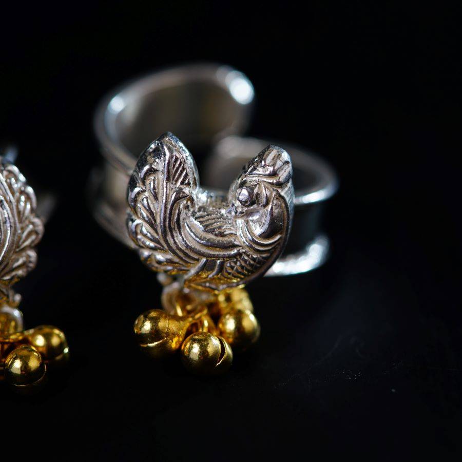 a pair of silver and gold rings on a black surface