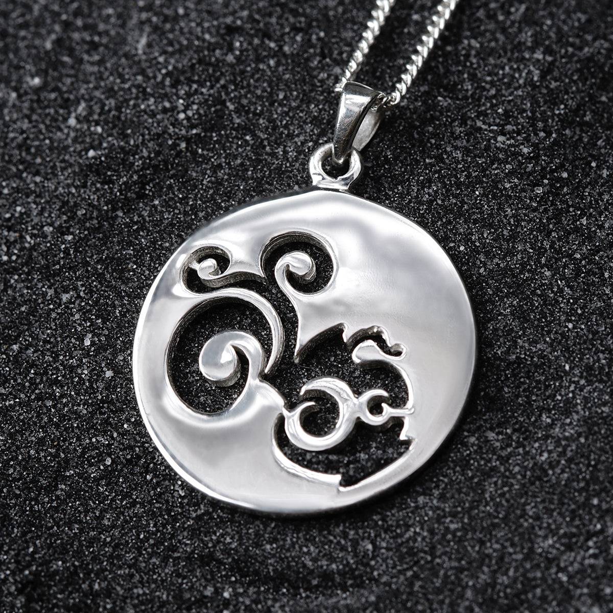 a silver pendant with an omen symbol on it