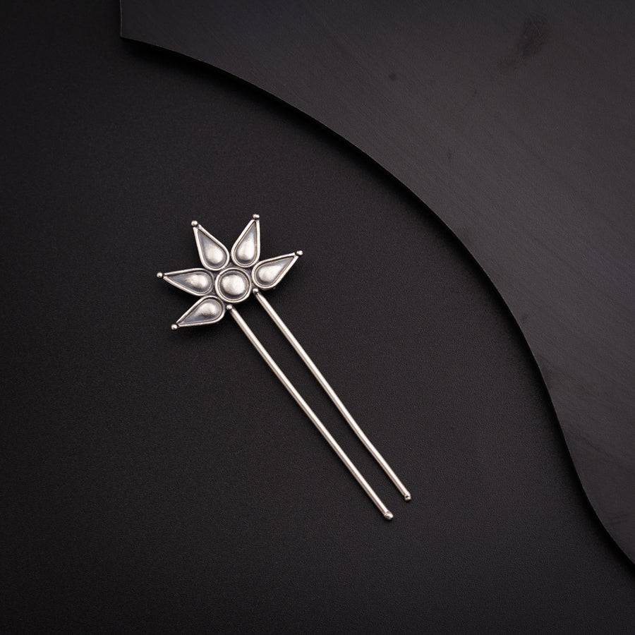 a silver pin with a flower on it
