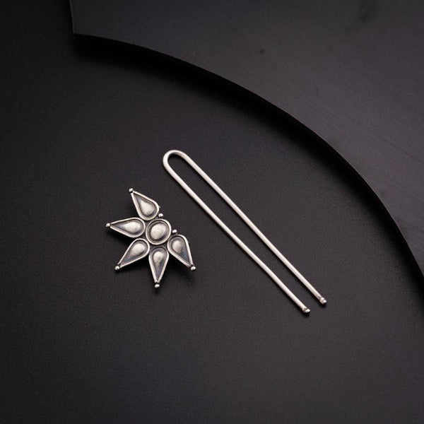 a pair of metal pins and a pin on a black surface