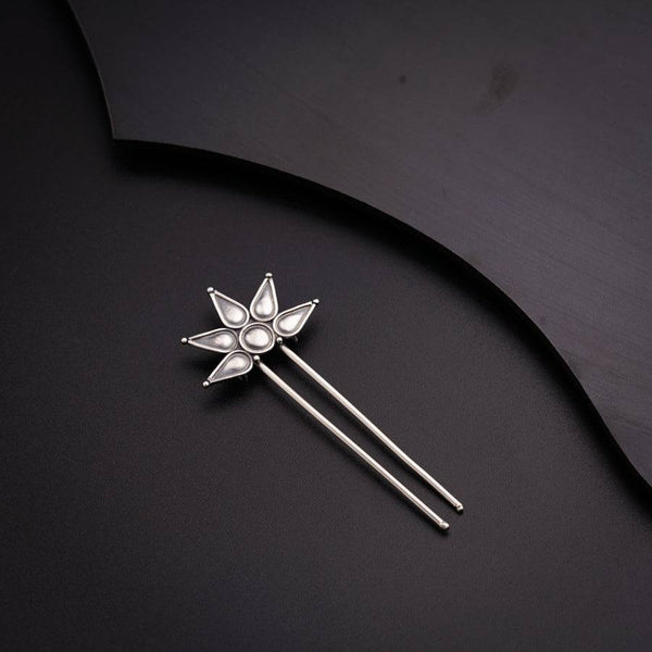 a close up of a brooch on a black surface