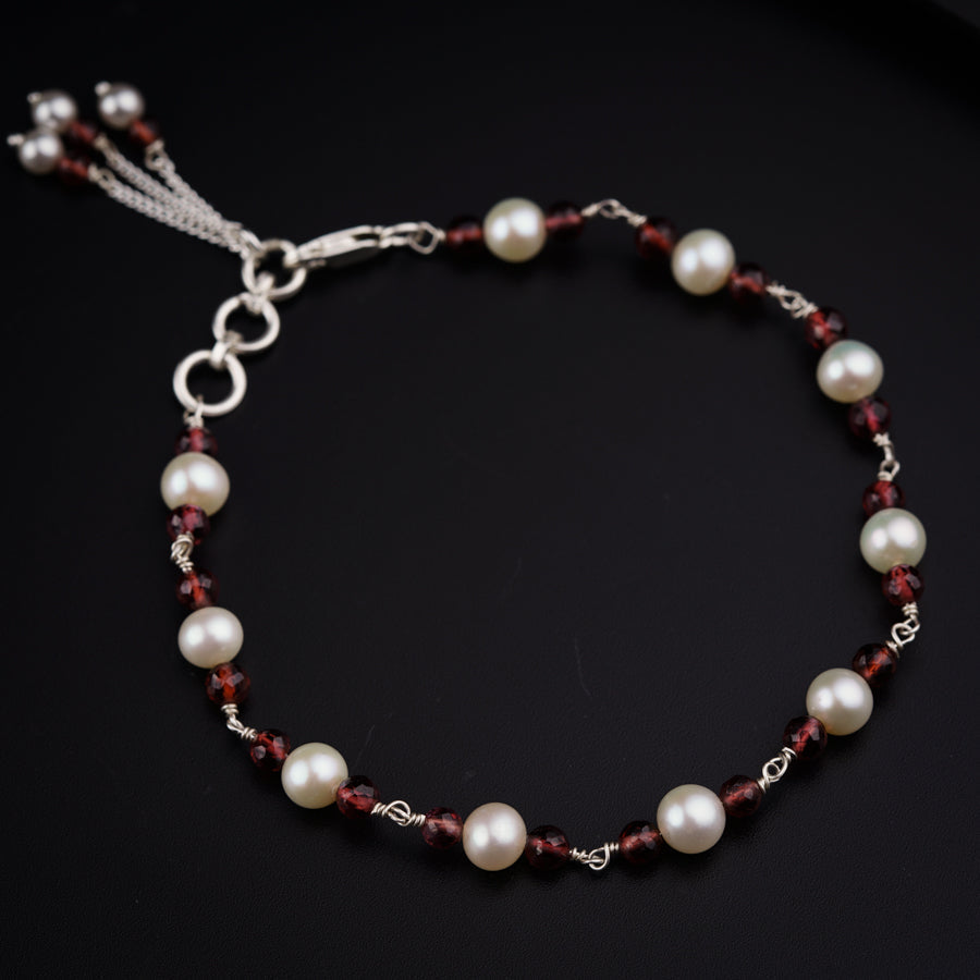 a red and white beaded bracelet on a black surface