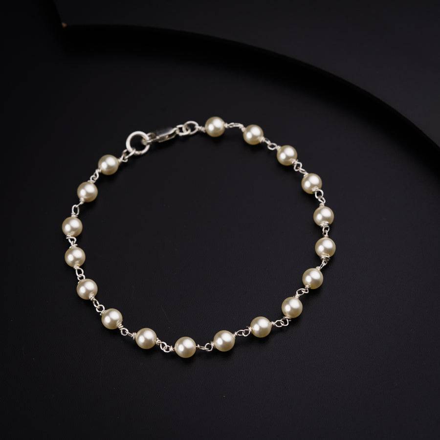 a bracelet with pearls on a black surface