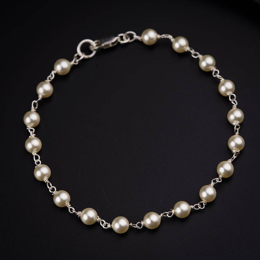a bracelet with pearls on a black background