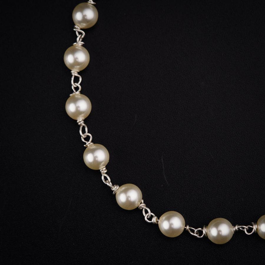 a necklace with pearls on a black background