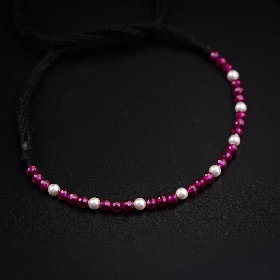 a red and white beaded necklace on a black background