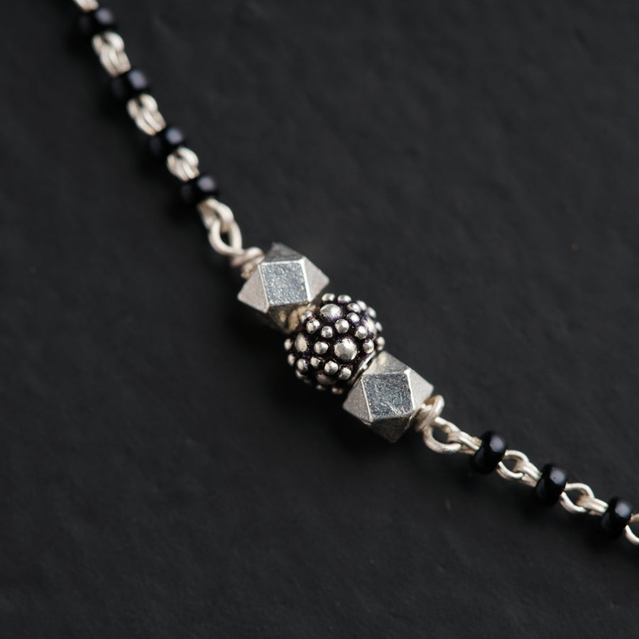 a black and silver beaded necklace with beads