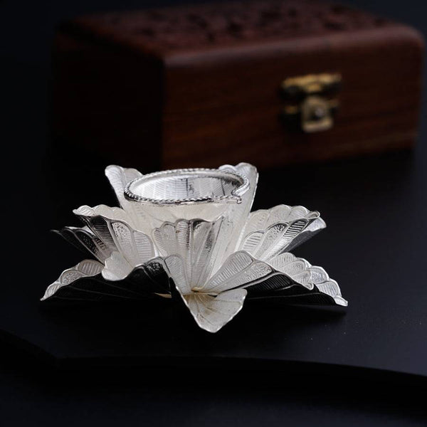 a silver vase sitting on top of a black table