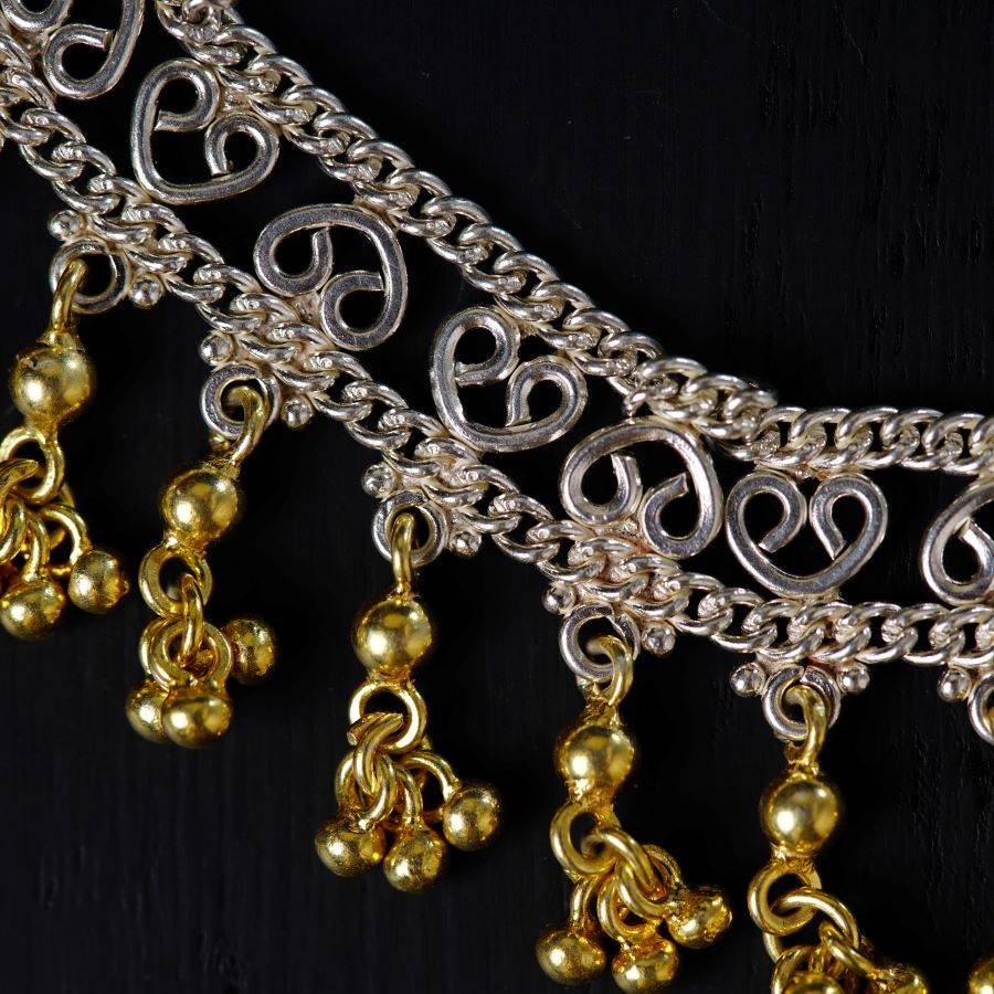 a close up of a gold and silver necklace