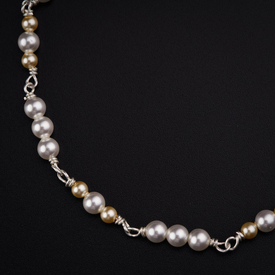 a necklace with pearls on a black background