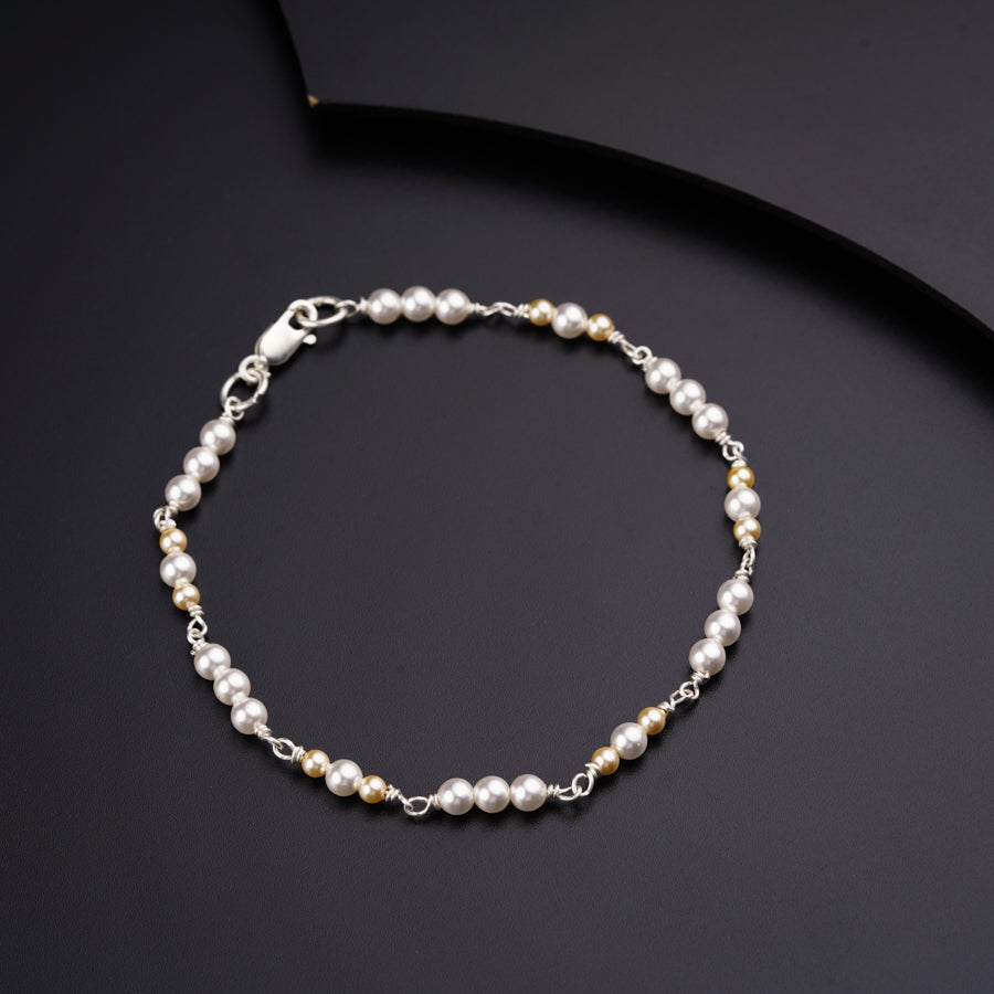a bracelet with pearls on a black surface