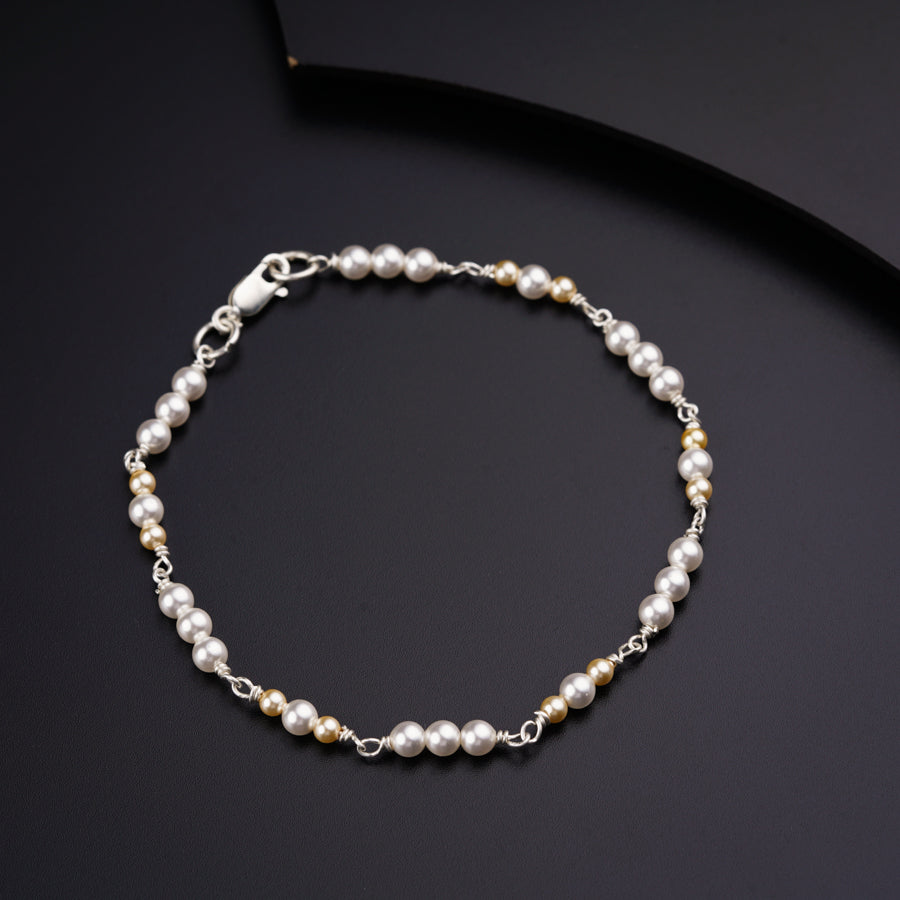 a bracelet with pearls on a black surface