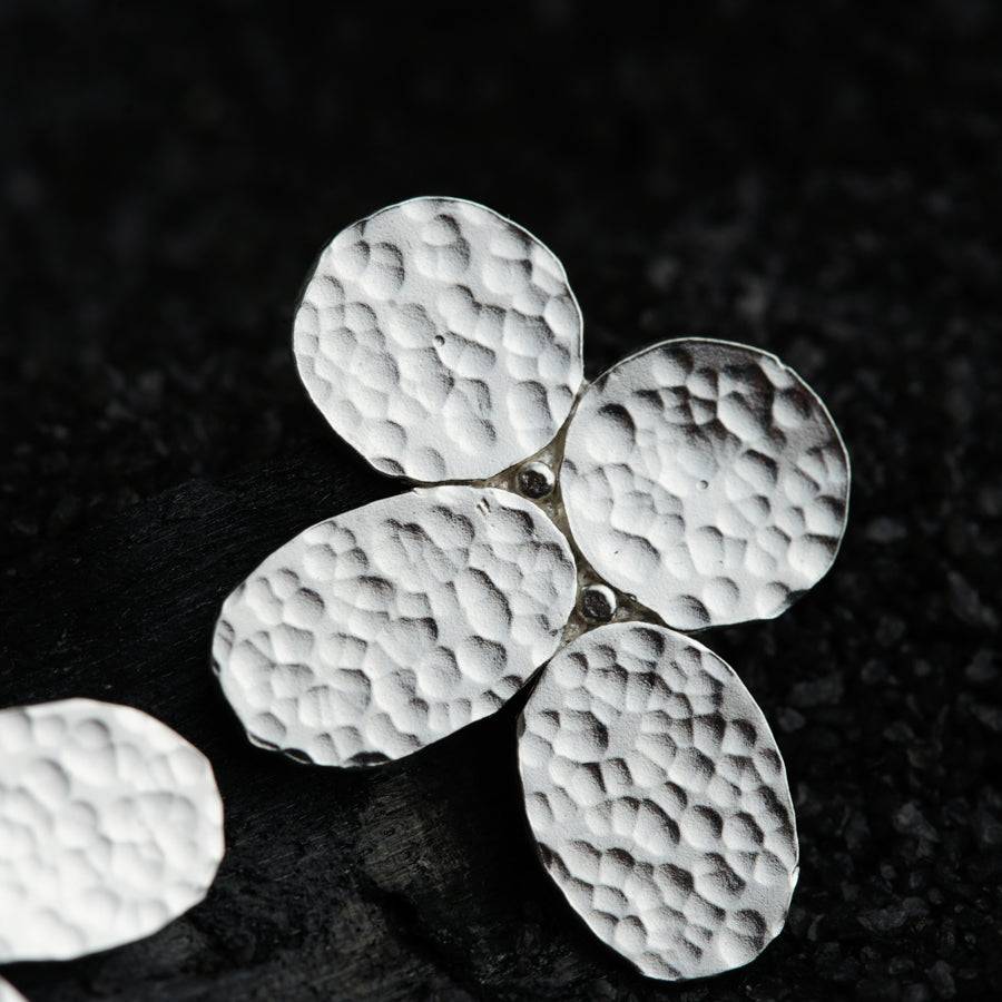 a close up of four white flowers on a black surface