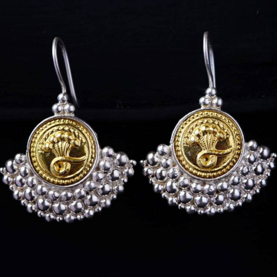a pair of silver and gold earrings